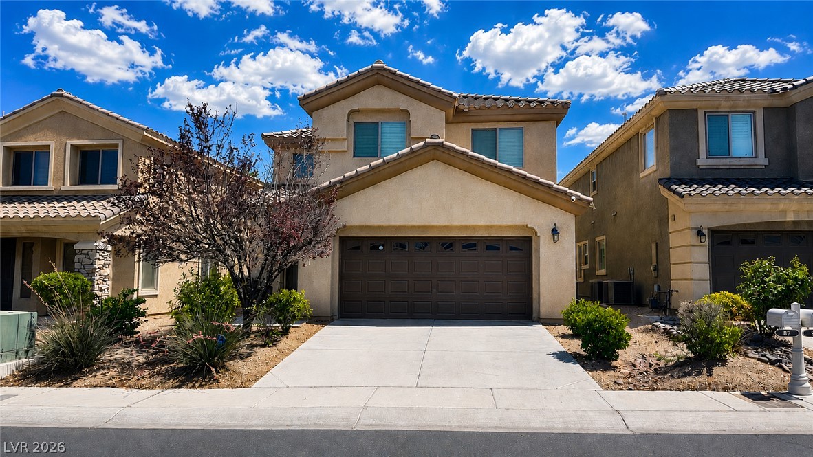 87 Tall Ruff Drive Las Vegas, NV 89148 - Photo 39 of 71 A well-kept driveway leads to this inviting stucco home with a tile roof and mature landscaping.