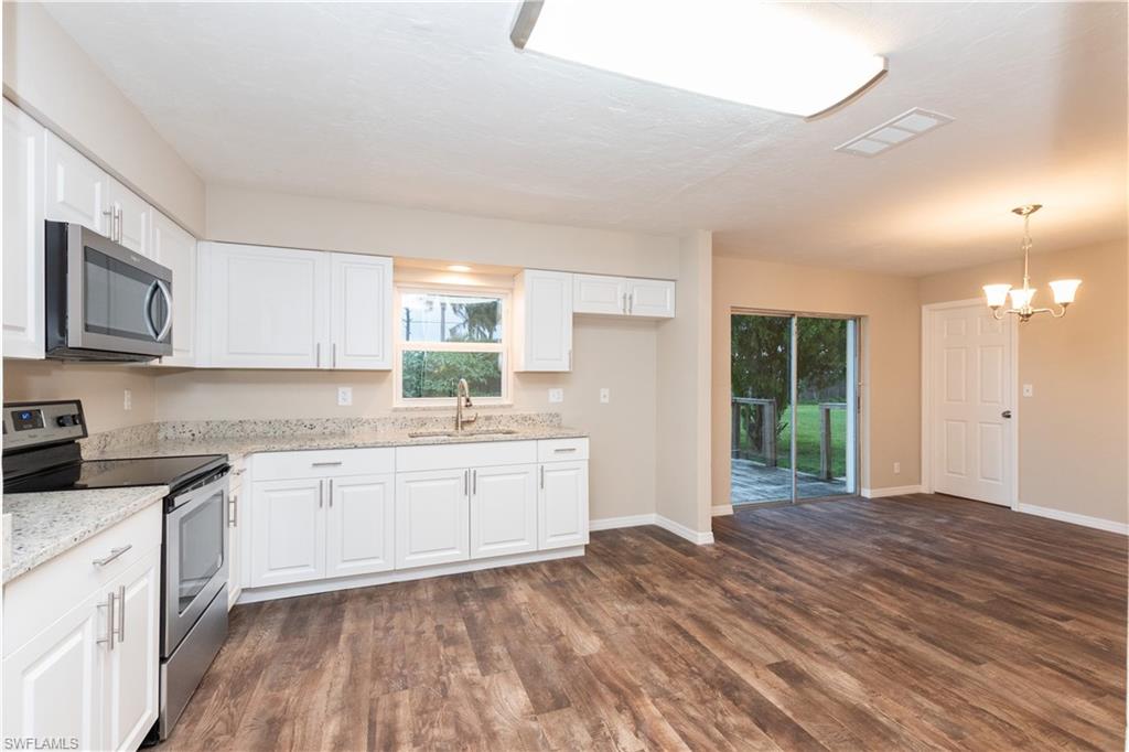 1770 52nd Terrace Southwest Naples, FL 34116 - Photo 6 of 23 a kitchen with granite countertop a stove a sink and a refrigerator