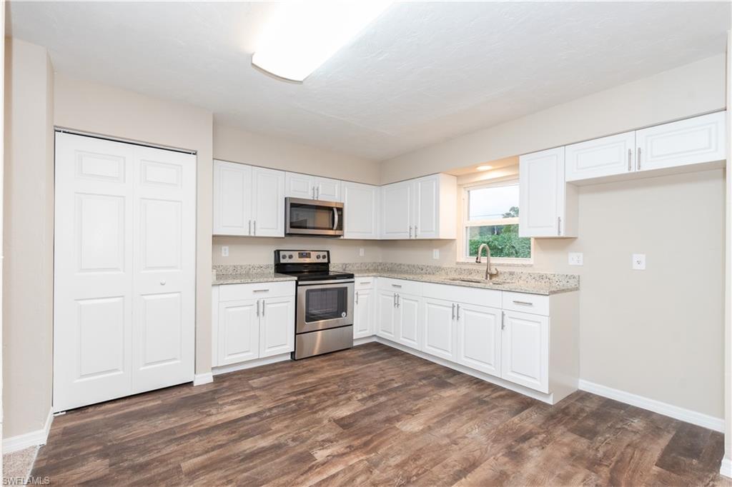 1770 52nd Terrace Southwest Naples, FL 34116 - Photo 7 of 23 a kitchen with granite countertop white cabinets and white appliances