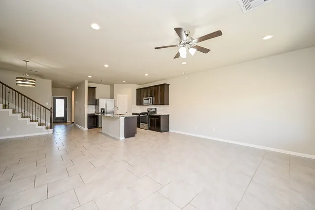 a view of a kitchen with furniture and stainless steel appliances