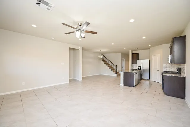 a view of empty room with wooden floor and ceiling fan