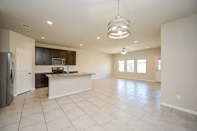 a large kitchen with kitchen island granite countertop stainless steel appliances lots of counter space and window