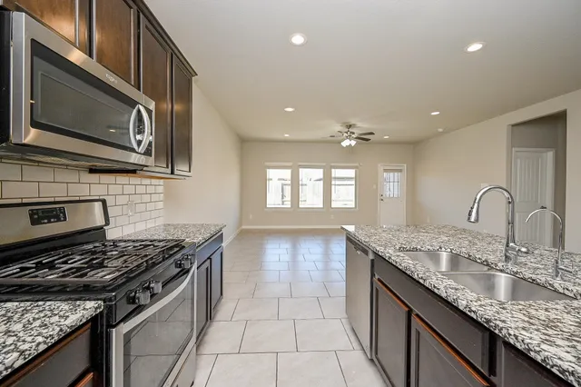 a kitchen with granite countertop stainless steel appliances and sink
