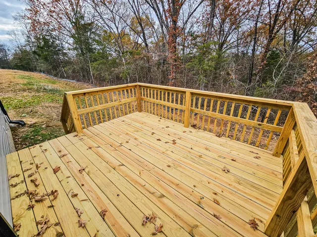 a view of balcony with wooden floor and fence