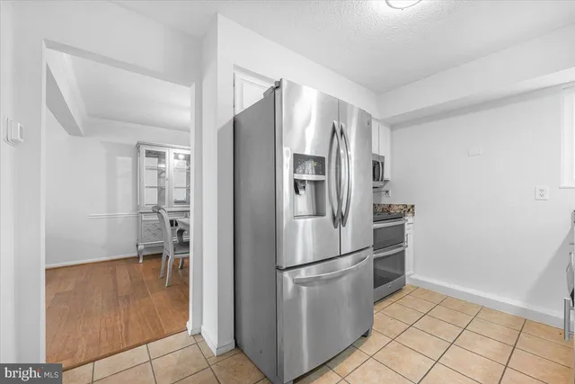 a kitchen with granite countertop white cabinets and stainless steel appliances