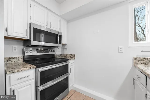 a large white kitchen with a sink and cabinets