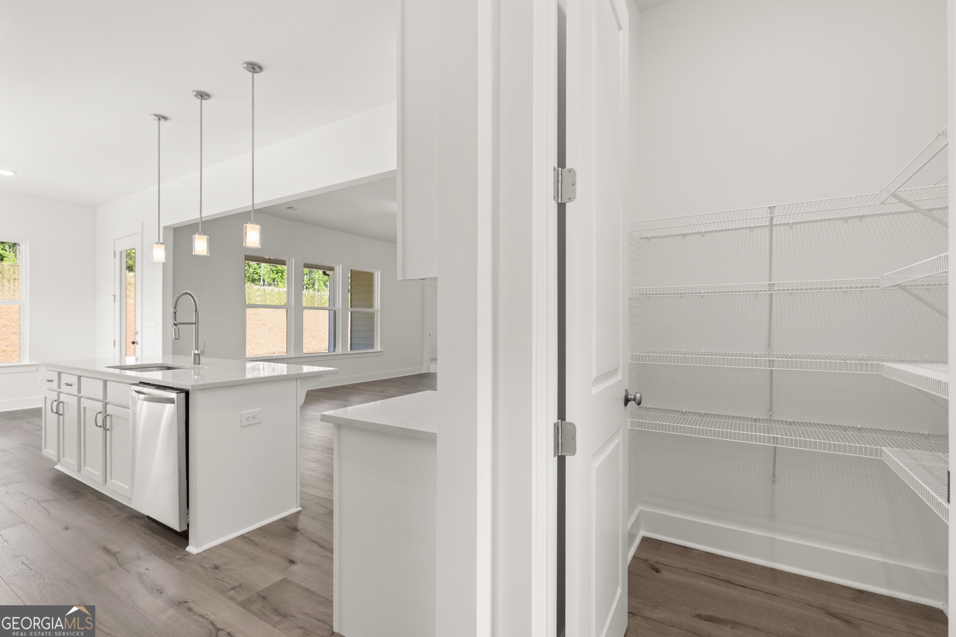 15 Overview Court Hoschton, GA 30548 - Photo 17 of 43 a view of a kitchen with white cabinets and wooden floor