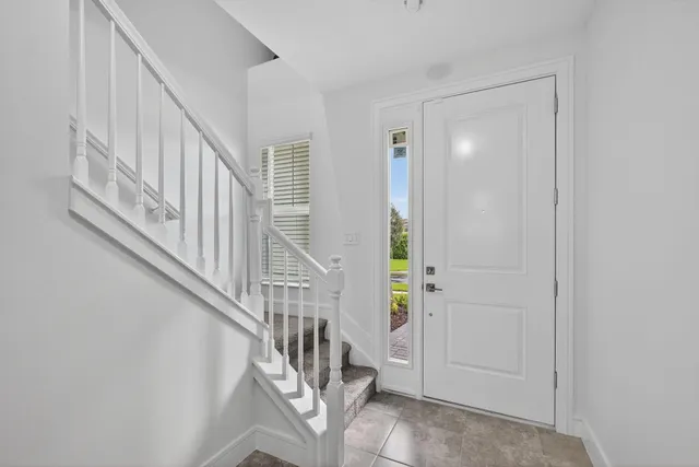 a view of staircase with railing and white walls