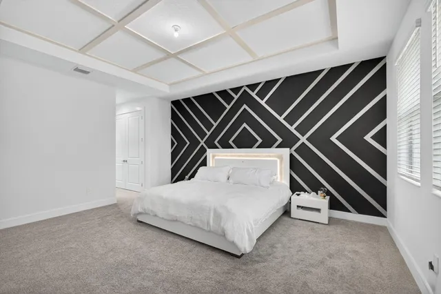 a bedroom with a bed and a painting on the wall