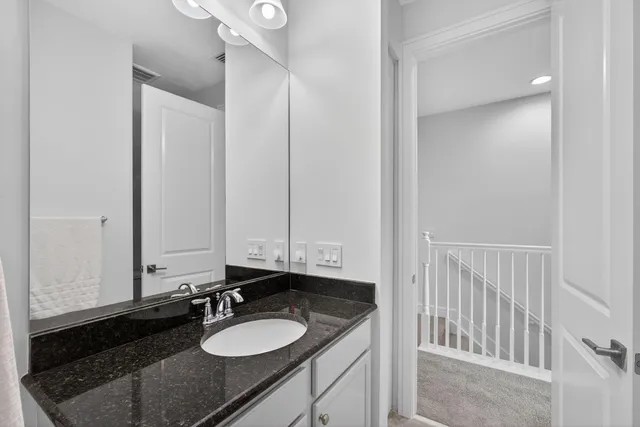 a bathroom with a granite countertop sink mirror and a bathtub