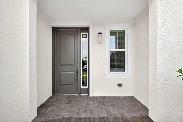 a front view of a house with a yard and potted plants
