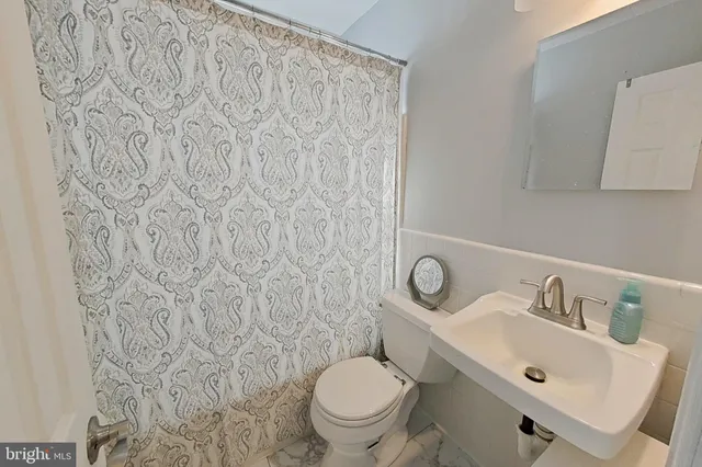 a bathroom with a toilet sink vanity and mirror