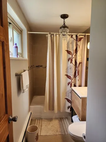 a bathroom with a shower a toilet and a sink