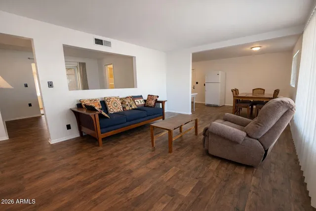 a living room with furniture and a wooden floor