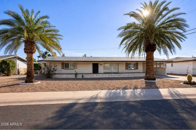 a front view of house with yard and car parked