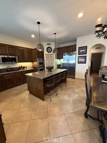 a large kitchen that has a lot of white cabinets and couches