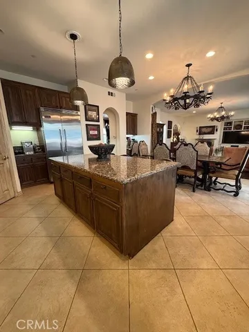 a kitchen with kitchen island granite countertop a sink counter top space appliances and cabinets