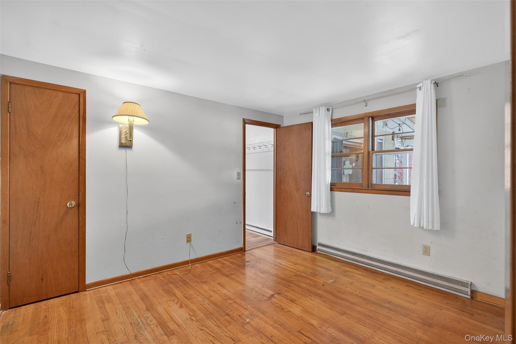 4030 Highway 209, Unit 4028 Stone Ridge, NY 12484 - Photo 16 of 22 an empty room with wooden floor and windows