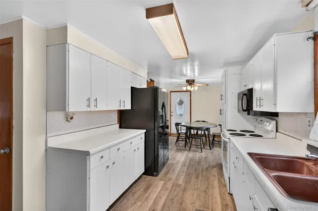 a kitchen with a sink a counter top space stainless steel appliances and a window