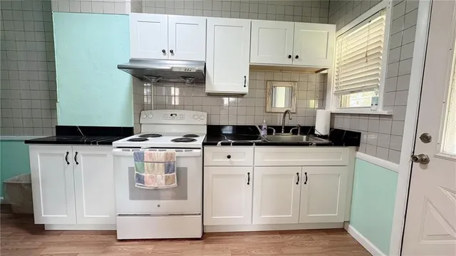a kitchen with cabinets appliances and a window