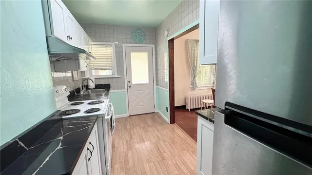 a kitchen with a refrigerator a stove and a window