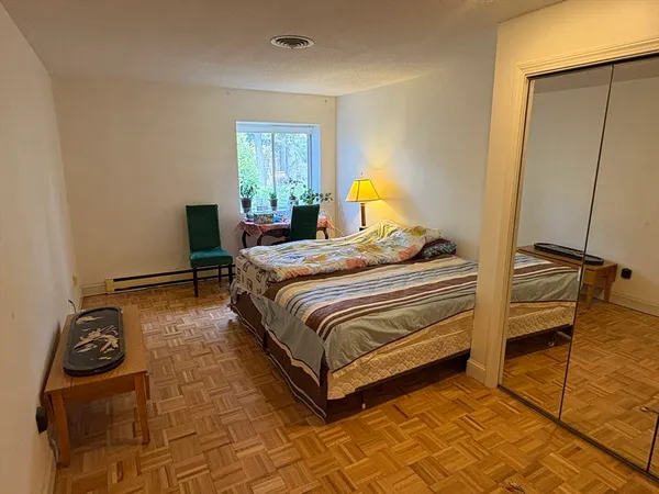 a bedroom with a bed and wooden floor