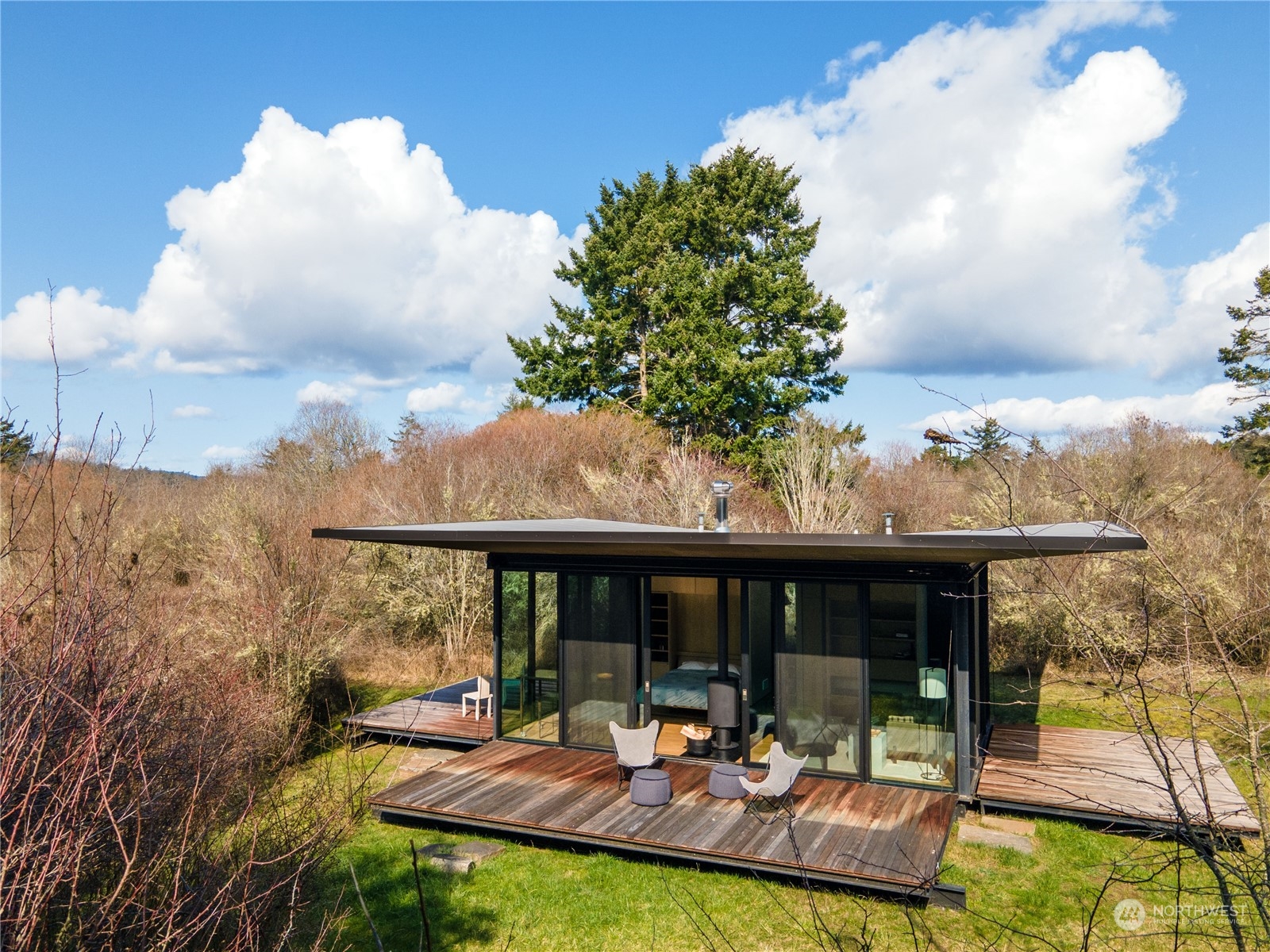 265 Rainshadow Road San Juan Island, WA 98250 - Photo 35 of 40 a view of a patio with couches table and chairs under an umbrella