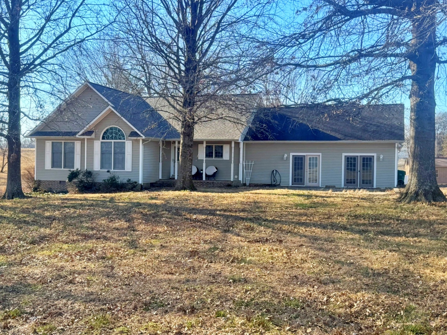a front view of a house with a yard and large tree