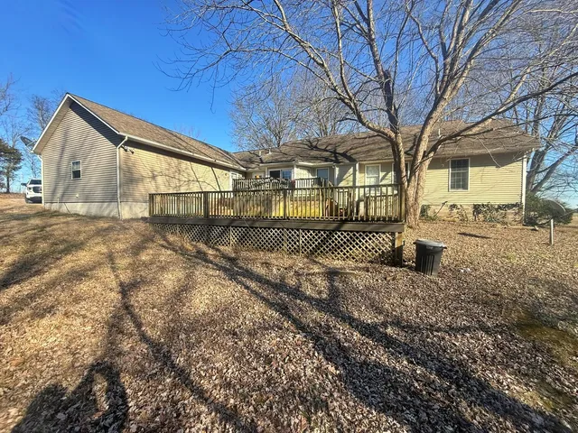 a view of dirt yard with a large tree