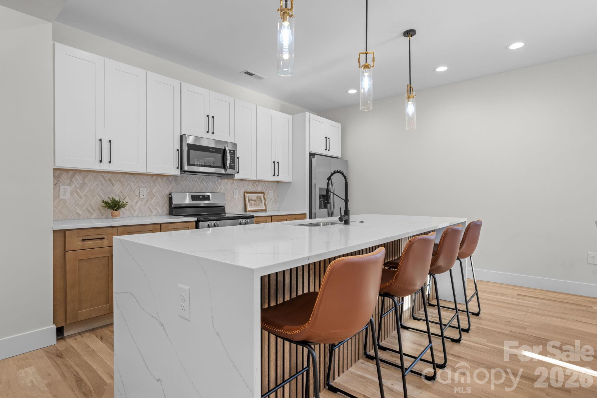 548 Car Farm Road Lincolnton, NC 28092 - Photo 4 of 41 a kitchen with stainless steel appliances a sink a stove a refrigerator cabinets and a dining table