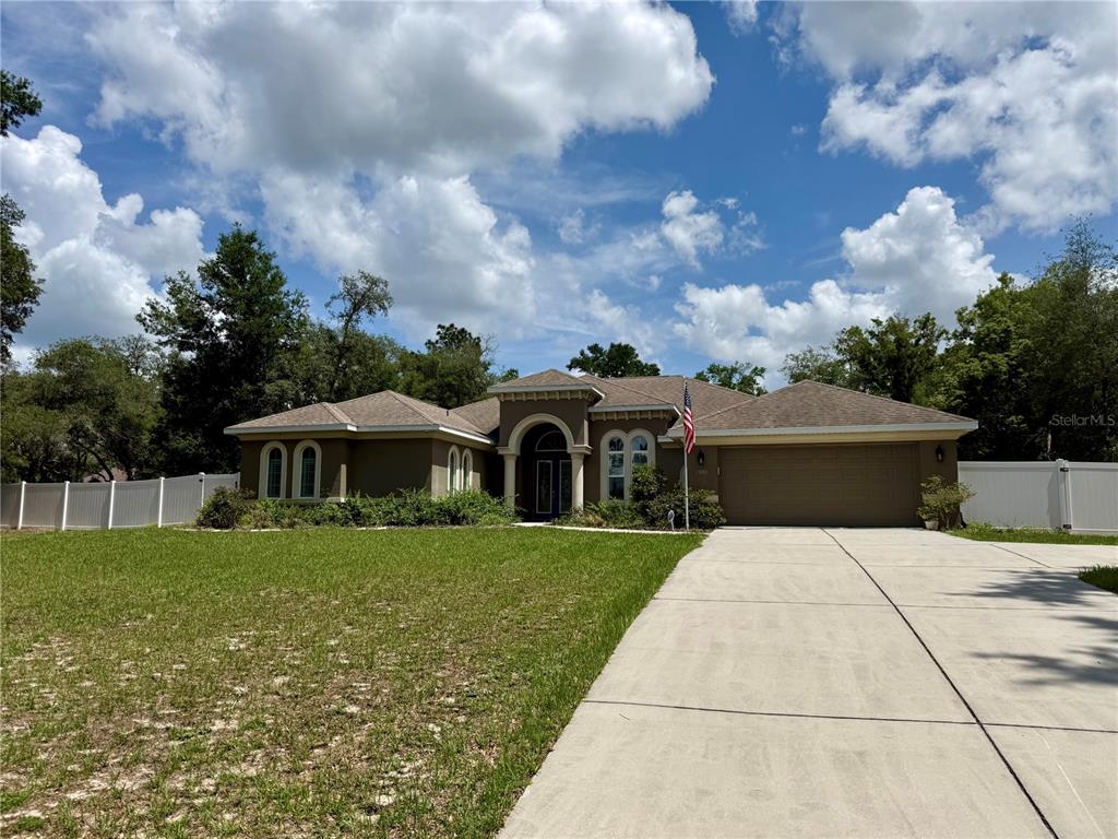 13110 Bamboo Street Spring Hill, FL 34609 - Photo 1 of 56 a front view of a house with garden