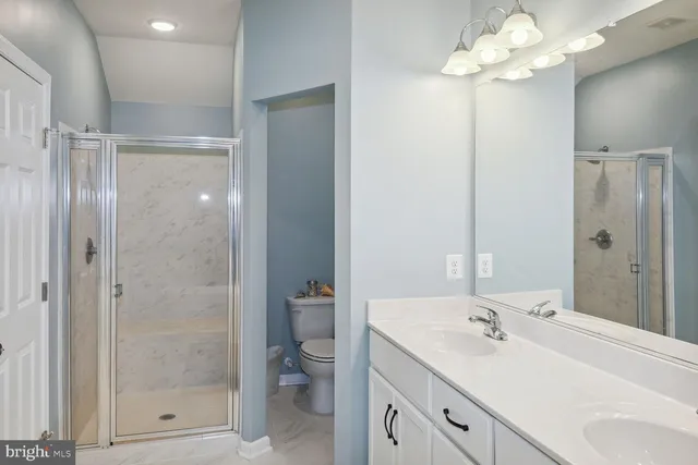 a bathroom with a shower sink vanity and mirror