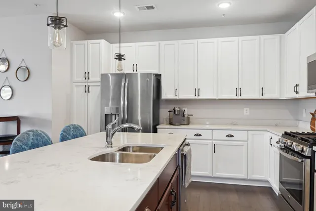 a kitchen with stainless steel appliances a sink stove and refrigerator