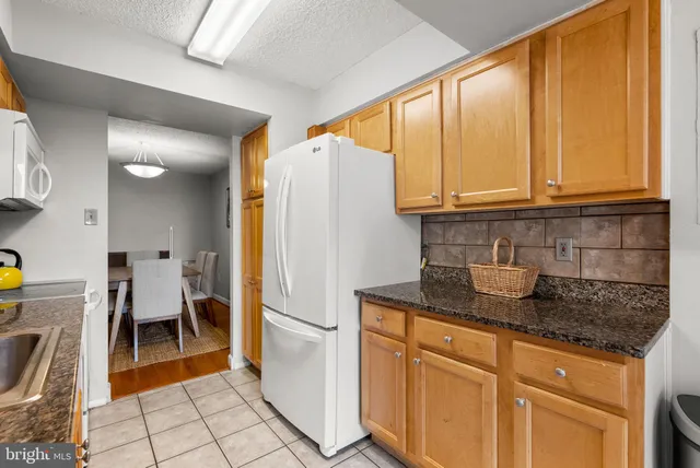 a kitchen with stainless steel appliances granite countertop a refrigerator sink and cabinets
