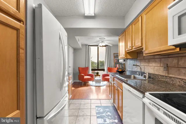 a open kitchen with stainless steel appliances granite countertop a refrigerator and a sink