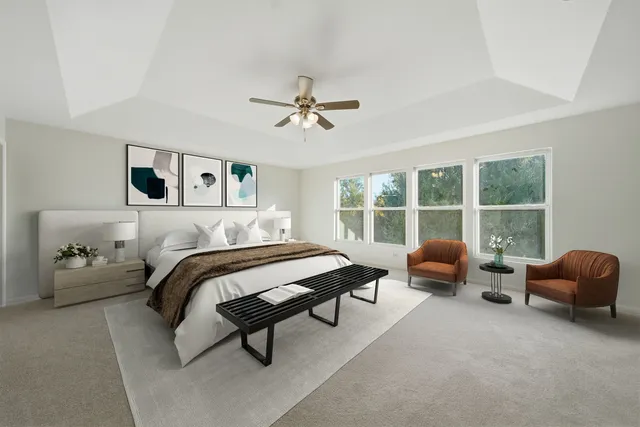 a bedroom with furniture and large windows