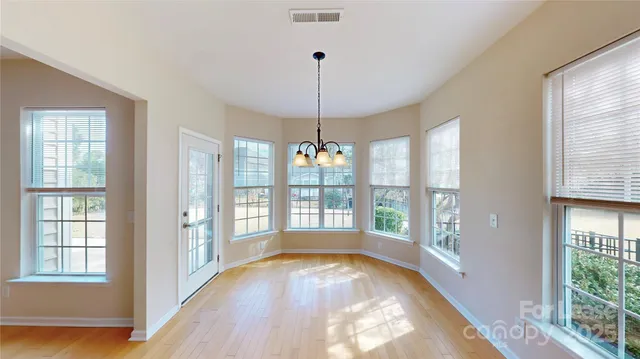 a view of an empty room with glass door and windows
