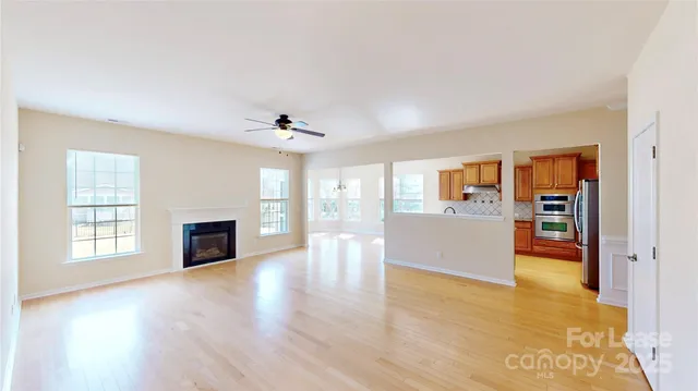 a view of empty room with wooden floor and fireplace