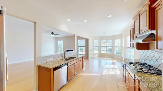 a view of a kitchen with kitchen island granite countertop a large window and a counter top space