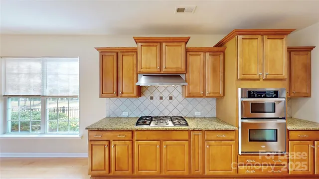a kitchen with stainless steel appliances granite countertop a sink and a refrigerator