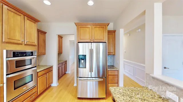 a kitchen with stainless steel appliances granite countertop a refrigerator and a stove top oven
