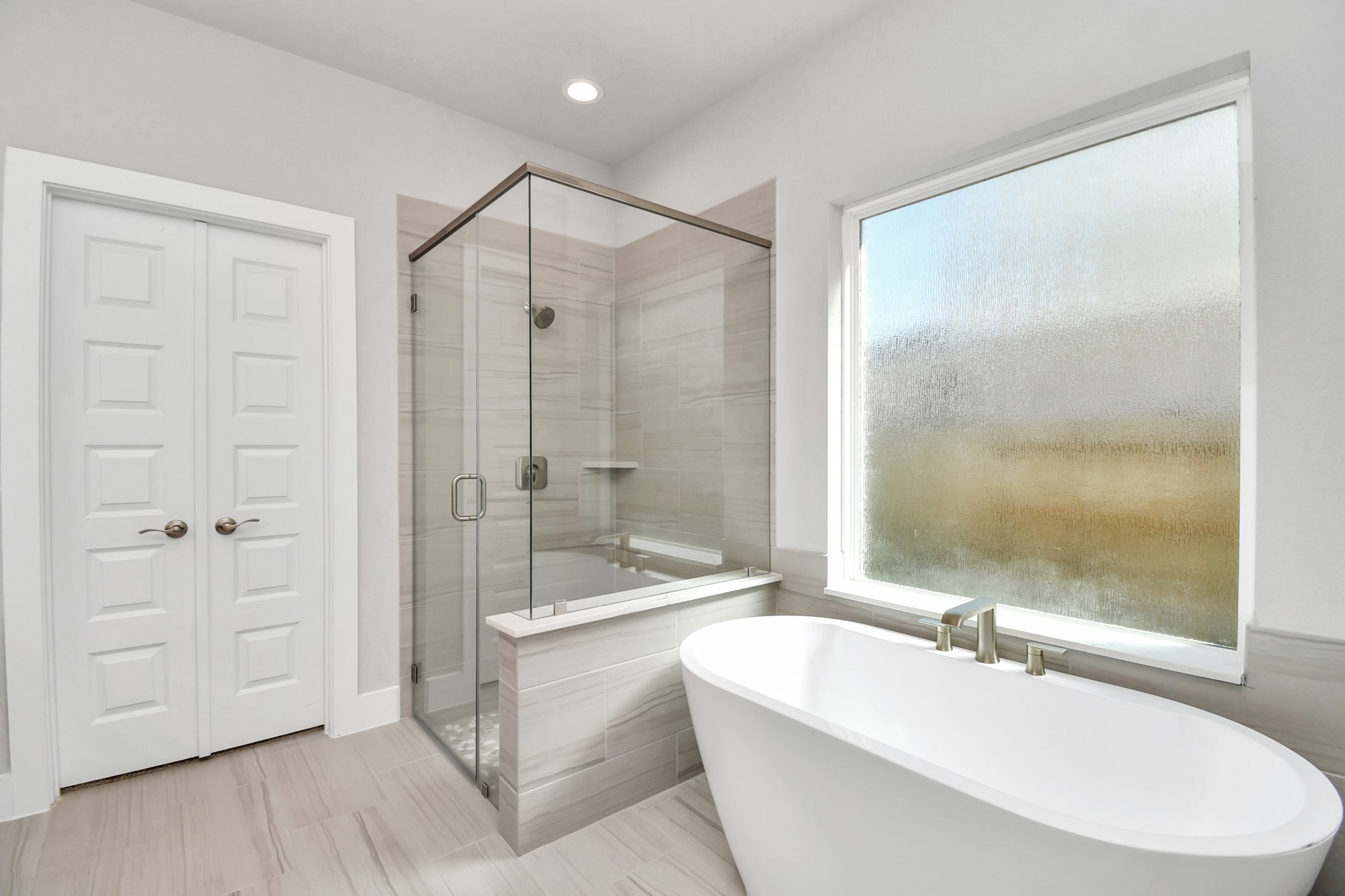 3106 Native Spg Drive Spring, TX 77373 - Photo 23 of 38 Indulge in a spa-like retreat within the confines of this primary bathroom. Delight in a spacious walk-in shower enveloped in stylish tile surround and unwind in a separate garden tub adorned with custom detailing. Sample photo of completed home with similar floor plan. Actual colors and selections may vary.