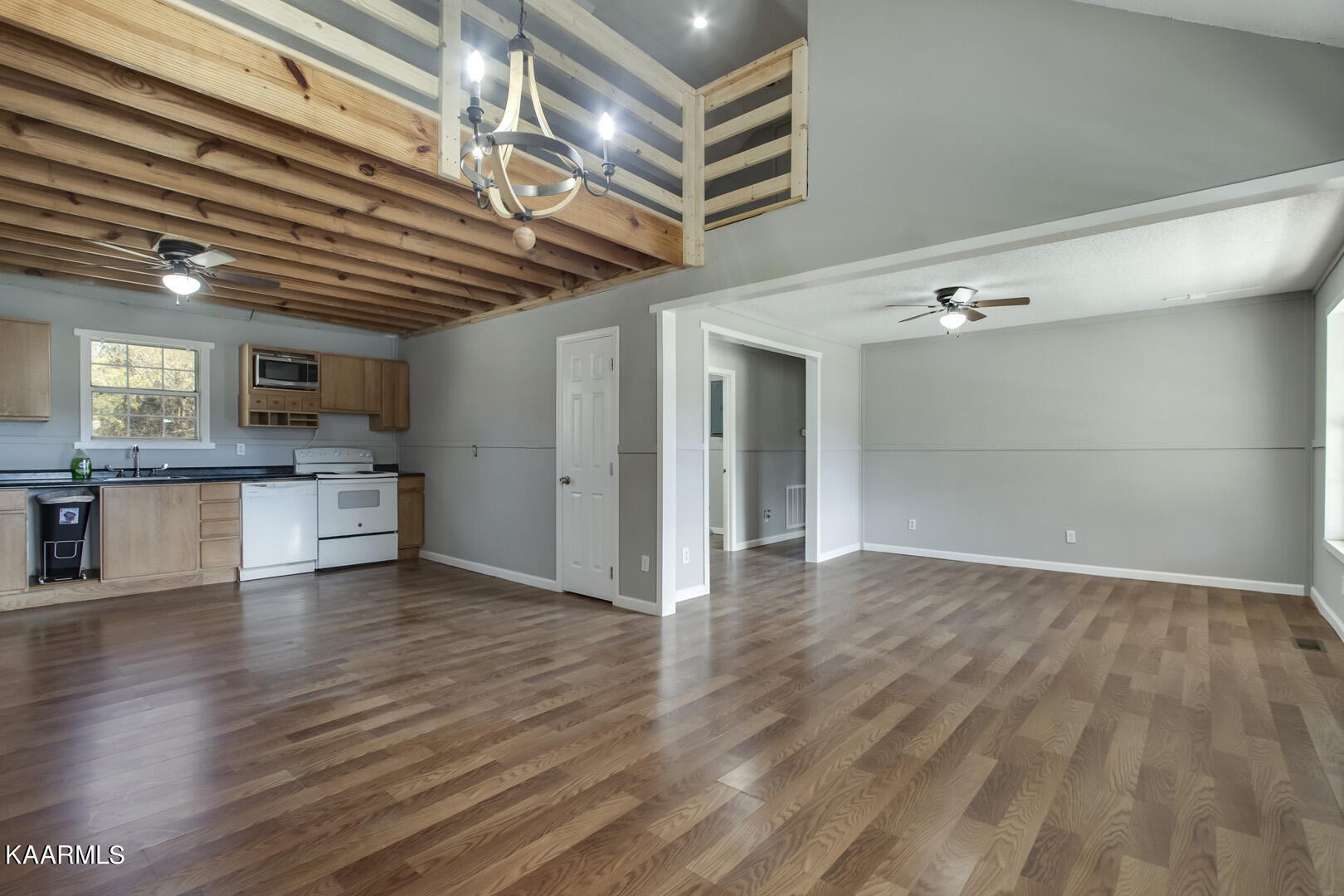199 Honeysuckle Road Loudon, TN 37774 - Photo 8 of 33 a view of an empty room with wooden floor and a kitchen