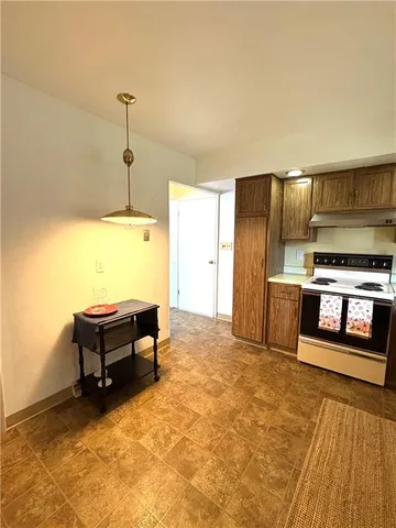 a kitchen with stainless steel appliances kitchen island granite countertop a refrigerator and a stove top oven