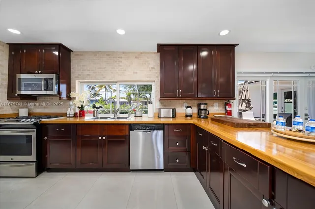 a kitchen with stainless steel appliances granite countertop wooden cabinets a stove top oven and granite counter tops