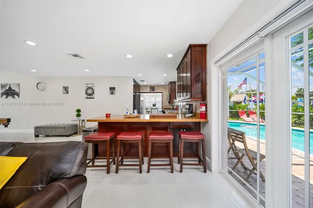 a view of kitchen with stainless steel appliances dining table and chairs