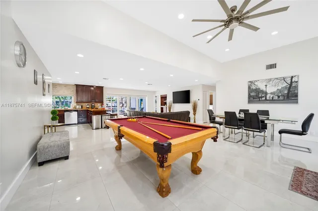 a living room with furniture a pool table and a fireplace