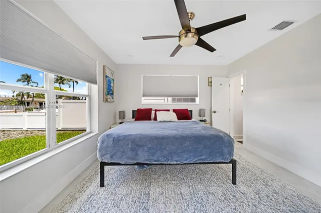 a spacious bedroom with a bed and a television