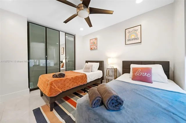 a bedroom with two bed and a flat screen tv