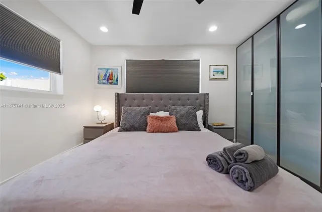 a large bedroom with a bed and a flat screen tv